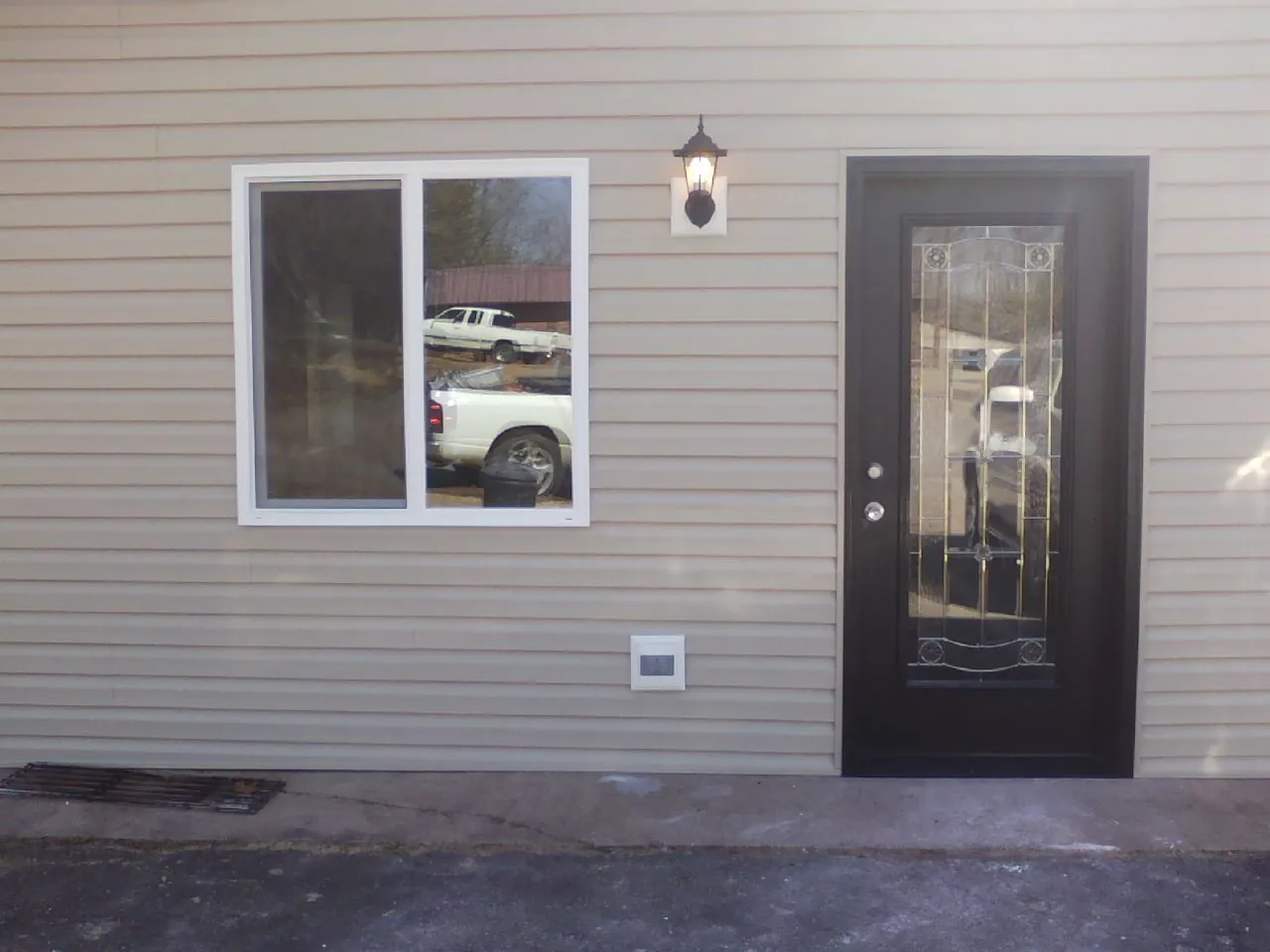 New siding, window and entry door on the side of an addition in Groveland